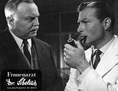 "Frauenarzt Dr.�Sibelius": Szenenfoto mit Hans Nielsen (l.) als Anwalt Dr. Reinhardt und Lex Barker als Dr. Georg Sibelius; mit freundlicher Genehmigung von "Pidax Film", welche das Melodram Anfang Juni 2013 auf DVD herausbrachte.