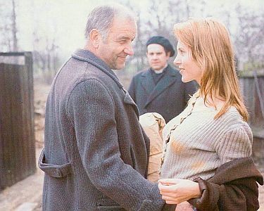 "Bittere Ernte":  Szenenfoto mit Armin Mueller-Stahl (Leon Wolny) und Anita Höfer als Pauline; im Hintergrund Gerd Baltus als Geistlicher; mit freundlicher Genehmigung von Pidax-Film, welche den Film am 21.08.2020 als Remastered Edition auf  DVD herausbrachte.