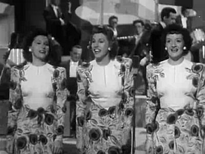 The Andrews Sisters in dem Film "Private Buckaroo" (1942); von links nach recht: Maxene, Patty und LaVerne Andrews; Lizenz: Der Film wurde vom Rechteinhaber, "Universal Pictures", bedingungslos in die Gemeinfreiheit entlassen und ist im Internet Archive archiviert und verfügbar. Quelle: Wikipedia
