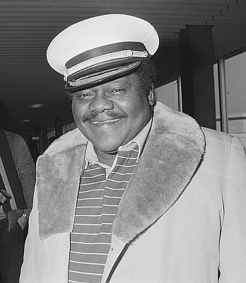 Fats Domino am 12. M�rz 1987 bei Ankunft auf dem Flughafen Amsterdam Schiphol; Rechteinhaber: Nationaal Archief�(Den Haag, Rijksfotoarchief; Bestandsnummer: 933-9199); Ausschnitt des Originalfotos; Urheber/Fotograf: Bart Molendijk / Anefo; Quelle: Wikimedia Commons; Lizenz:  CC0 1.0 (Verzicht auf das Copyright)