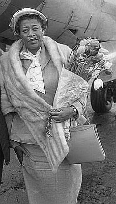 Ella Fitzgerald am 5. Mai 1957 bei Ankunft auf dem Flughafen Amsterdam Schiphol; Rechteinhaber: Nationaal Archief&nbsp;(Den Haag, Rijksfotoarchief; Bestandsnummer: 908-5518); Urheber/Fotograf: Harry Pot / Anefo; Quelle (Originalfoto): Wikimedia Commons; Lizenz:  CC0 1.0 (Verzicht auf das Copyright)