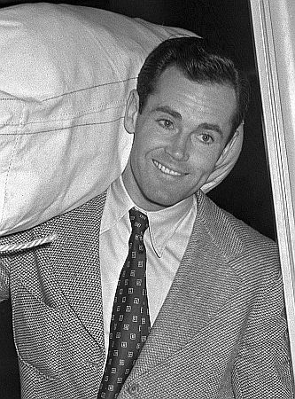 Henry Fonda Ende November 1942 mit einer Tasche auf der Schulter beim Dienstantritt in der "United States Navy"; Quelle: Wikimedia Commons (Ausschnitt des Originalfotos) von "UCLA Library Digital Collection"; Urheber: "Los Angeles Times"; Lizenz: CC BY 4.0 Deed