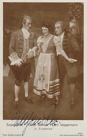 Eugen Rex (links) auf einer Künstlerkarte mit Hilde Wörner und Kurt Vespermann; Urheber: Fotoatelier "Zander & Labisch" (Albert Zander u. Siegmund Labisch (1863–1942)); Quelle: www.cyranos.ch; Lizenz: gemeinfrei