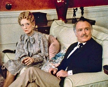 Agatha Christie: Miss Marple Collection: Szenenfoto aus "Mord mit doppeltem Boden" mit Bette Davis als Carrie Louise Serrocold und John Mills als Lewis Serrocold; mit freundlicher Genehmigung von Pidax-Film, welche drei spannende Agatha-Christie-Krimis Mitte Septenber 2019 auf DVD herausbrachte.