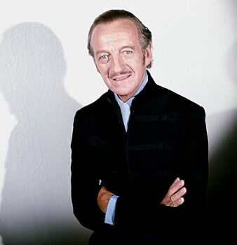 David Niven, aufgenommen im Jahre 1973 in London; Quelle: commons.wikimedia.org bzw. Wikipedia; Urheber: Allan Warren (www.allanwarren.com);  Diese Datei ist unter der Creative Commons-Lizenz Namensnennung-Weitergabe unter gleichen Bedingungen 3.0 Unported lizenziert. Es ist erlaubt, die Datei unter den Bedingungen der GNU-Lizenz für freie Dokumentation, Version 1.2 oder einer späteren Version, veröffentlicht von der Free Software Foundation, zu kopieren, zu verbreiten und/oder zu modifizieren; es gibt keine unveränderlichen Abschnitte, keinen vorderen und keinen hinteren Umschlagtext. Der vollständige Lizenztext ist im Kapitel GNU-Lizenz für freie Dokumentation verfügbar.