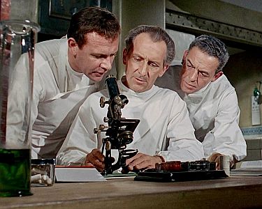 "Insel des Schreckens": Szenenfoto mit Peter Cushing (Mitte) als Pathologe Dr. Stanley mit Edward Judd (l.) als Dr. West, Experte fr Knochenkrankheiten, und Eddie Byrne als Arzt Dr. Landers; mit freundlicher Genehmigung von Pidax Film, welche den Grusel-Schocker im November 2024 auf DVD herausbrachte.