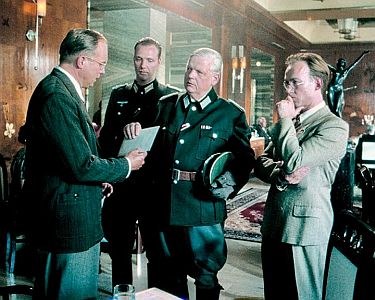 "BonhoefferDie letzte Stufe": Szenenfoto mit Ulrich Tukur (l.) als Dietrich Bonhoeffer, Christian Doermer (3. von links/Mitte) als General Hans Oster und Ulrich Noethen (r.) als Hans von Dohnanyi; mit freundlicher Genehmigung von Pidax Film, welche die Filmbiografie am 17. Oktober 2024 auf DVD herausbrachte.