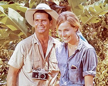 "Die Schurken von Bolivar (1968, "The Pink Jungle"): Szenenfoto mit James Garner als Modefotograf Ben Morris und Eva Renzo als das Model Alison Duquesne; mit freundlicher Genehmigung von Pidax-Film, welche die Agentenkomödie am 9. April 2021 auf DVD herausbrachte.