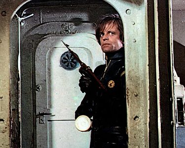 "Der Mann mit der Torpedohaut": Szenefoto mit Klaus Kinski als Agent Pavel Richko; mit freundlicher Genehmigung von Pidax-Film, welche den Krimi am 11. Juli 2024 auf DVD herausbrachte.