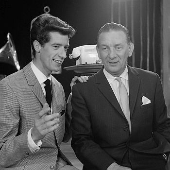 Rudi Carrell im August 1960 mit seinem Vater André; Rechteinhaber: Nationaal Archief (Den Haag, Rijksfotoarchief; Ausschnitt des Originalfotos; Bestandsnummer: 911-5182); Urheber/Fotograf: Henk Lindeboom / Anefo; Quelle: Wikimedia Commons; Lizenz: CC BY-SA 3.0 NL bzw. CC0 1.0