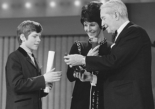 Heintje am 27.02.1970 mit Maurice Chevalier und Mies Bouwman bei der Preisverleihung des "EdisonAward" anlsslich der "Grand Gala du Disque" in Amsterdam; Rechteinhaber: Nationaal Archief (Den Haag, Rijksfotoarchief; Bestandsnummer: 923-3007); Urheber/Fotograf: Rob Mieremet / Anefo; Quelle: Wikimedia Commons (Ausschnitt des Originalfotos); Lizenz:CC BY-SA 3.0 NL bzw. CC0 1.0 (Verzicht auf das Copyright)