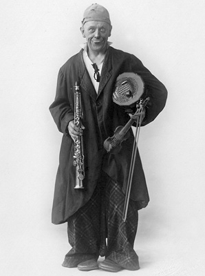 Grock 1918 mit Konzertina, seiner kleiner Geige und einem Sopransaxofon in Liverpool; Copyright RaymondNaef